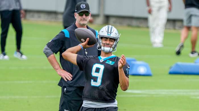 Bryce Young throws the quarterback while Frank Reich stands behind him and watches